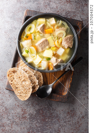 Finnish and Swedish Kottsoppa soup with beef, potatoes, carrots, leeks, celery and parsnip close-up in a plate. Vertical top view Finnish and Swedish Kottsoppa soup with beef, potatoes, carrots, leeks, celery and parsnip close-up in a plate. Vertical top view 107084872