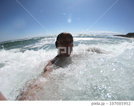 Windy ocean waves splashing on a guy Windy ocean waves splashing on a guy 107085952