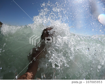 Windy ocean waves splashing on a guy Windy ocean waves splashing on a guy 107085953