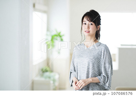 リビングでくつろぐ若い女性 リビングでくつろぐ若い女性 107086576