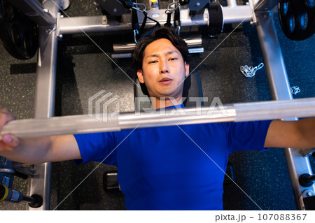 ジムで体を鍛える若い男性 107088367
