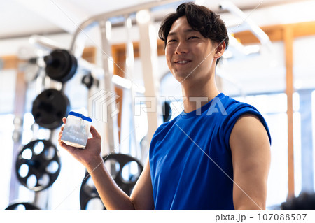 ジムで水分補給する若い男性 107088507