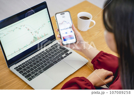 スマホを見て投資をする女性 スマホを見て投資をする女性 107089258