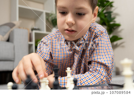 Little boy playing chess. Board games for children 107089584