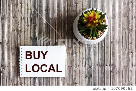 buy local text on notepad and wooden background- shopping concept buy local text on notepad and wooden background- shopping concept 107090363