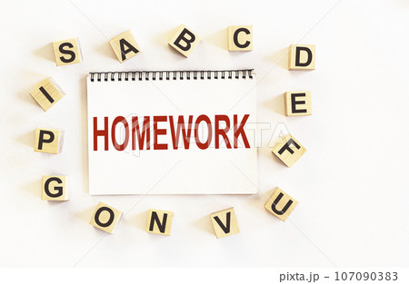 Text HOMEWORK, on notepad and white background, around are wooden cubes with letters 107090383