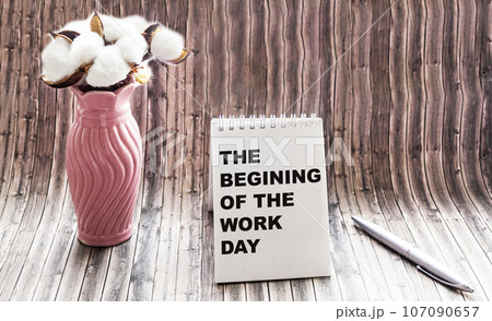 the text THE BEGINNING OF THE WORK DAY is written on a notebook, next to a bouquet of flowers the text THE BEGINNING OF THE WORK DAY is written on a notebook, next to a bouquet of flowers 107090657