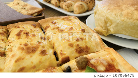 Homemade square pizza with cheese on wooden table Square pizza - Four seasons - Organic pizza - healthy pizza Homemade square pizza with cheese on wooden table Square pizza - Four seasons - Organic pizza - healthy pizza 107096479