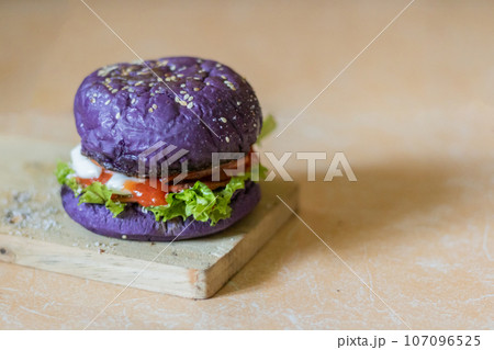 close up photo of a home-made purple burger placed on a ceramic table. Hamburger. Fast Food. Culinary 107096525
