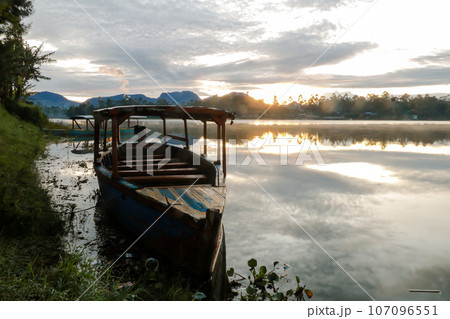 photo of dramatic sunrise view on the lake. with the boat being the foreground. Landscape. Nature. 107096551