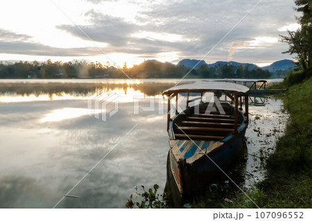 photo of dramatic sunrise view on the lake. with the boat being the foreground. Landscape. Nature. 107096552