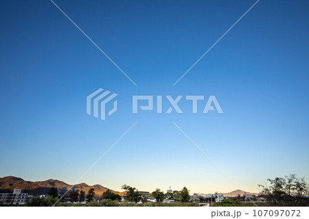京都盆地の秋、桂川サイクルロードから眺めた秋晴れの澄んだ夕空、遠景に比叡山 107097072