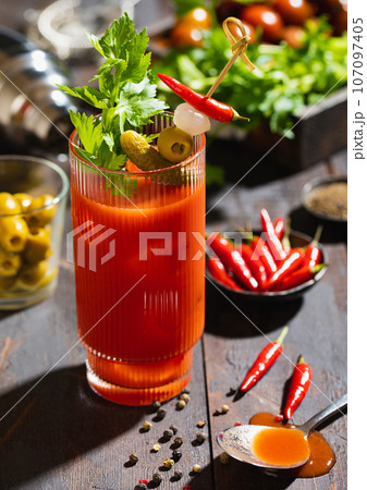 Bloody mary cocktail with pepper and hot snacks on dark board.hard light. Bloody mary cocktail with pepper and hot snacks on dark board.hard light. 107097405