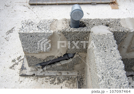 Laying a sewer pipe in the bathroom wall during the construction of a house Laying a sewer pipe in the bathroom wall during the construction of a house 107097464