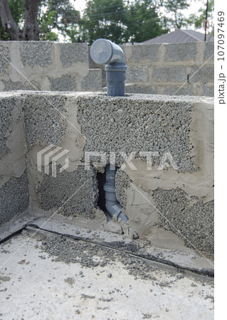 Wall-mounted sewer pipe for a washbasin in a bathroom during the construction of walls from expanded clay concrete blocks 107097469