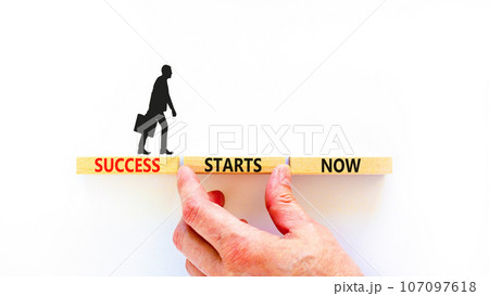 Success starts now symbol. Concept word Success starts now on beautiful wooden block. Businessman hand. Beautiful white table background. Business motivational success starts now concept. Copy space. 107097618