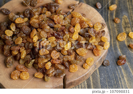Dried yellow golden raisins on a board Dried yellow golden raisins on a board 107098831