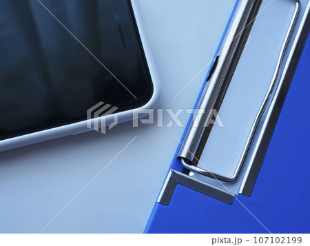 テーブルに置かれたバインダーとスマートフォン テーブルに置かれたバインダーとスマートフォン 107102199