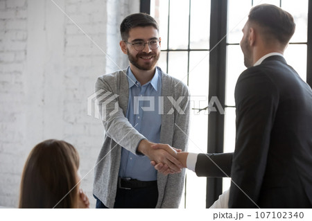 Male colleagues shake hands get acquainted at briefing Male colleagues shake hands get acquainted at briefing 107102340