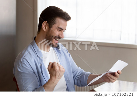 Overjoyed man reading good news, holding paper, celebrate success Overjoyed man reading good news, holding paper, celebrate success 107102521
