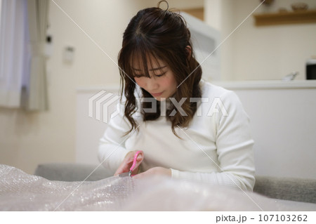 緩衝材を切る女性 107103262