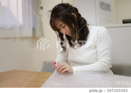 緩衝材を切る女性 107103263
