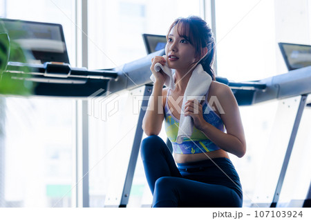 スポーツジムでトレーニングする若い女性 スポーツジムでトレーニングする若い女性 107103924
