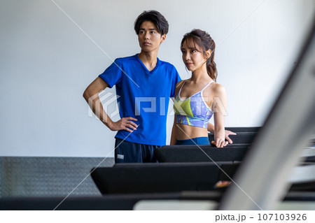 スポーツジムでトレーニングする若い男女 スポーツジムでトレーニングする若い男女 107103926