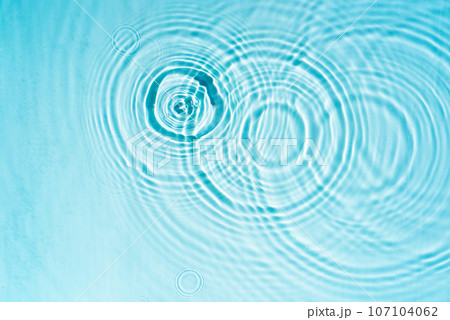 Circles and waves on blue water in sunlight 107104062