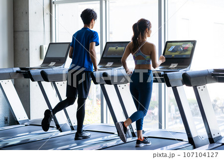 スポーツジムでトレーニングする若い男女 107104127