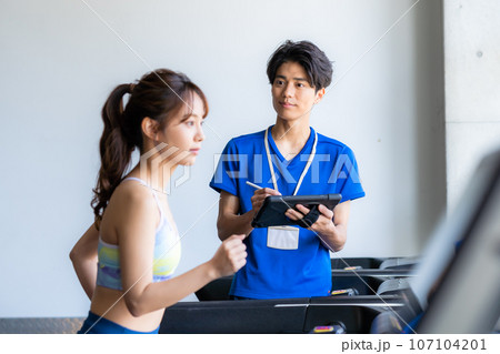 スポーツジムでトレーニングする若い女性 スポーツジムでトレーニングする若い女性 107104201