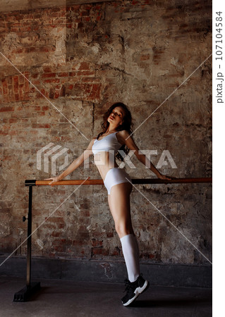 Beautiful sportswoman on the background of a brick wall 107104584