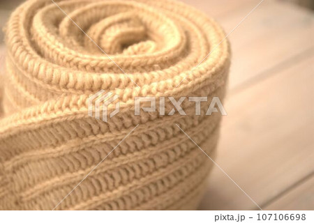 くるくると巻いたニットセーターの袖 107106698