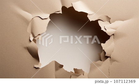 Hole in cardboard paper with torn edges Hole in cardboard paper with torn edges 107112369