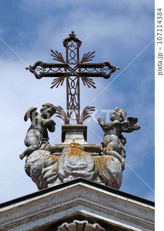 Angels kneeling under the cross, statue on facade of the Mantua Cathedral dedicated to Saint Peter, Mantua, Italy 107114384