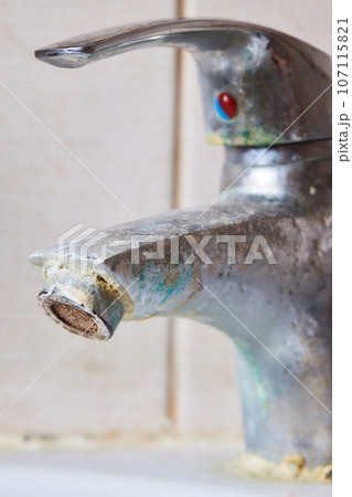 Rusted faucet, macro shot of rusted faucet. Water scarcity and water consumption concept idea. Rusted faucet, macro shot of rusted faucet. Water scarcity and water consumption concept idea. 107115821
