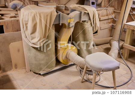 close up of a carpenter screwed a hinge on a wooden plank. 107116908