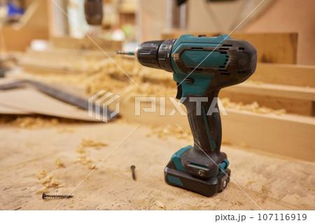 close up of a carpenter screwed a hinge on a wooden plank. close up of a carpenter screwed a hinge on a wooden plank. 107116919
