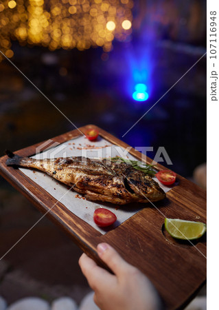 Tray with tasty grilled dorado fish on wooden background 107116948