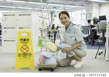 オフィス内の清掃道具をチェックするシニア女性清掃員 107117186