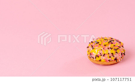 Cake with multi-colored confectionery dressing on a pink background 107117751