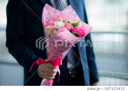 花束を持つスーツの男性 107121412