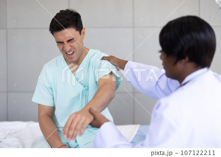 Patient sport male meeting physiotherapist doctor for muscle joint pain physical therapist recovery in hospital clinic Patient sport male meeting physiotherapist doctor for muscle joint pain physical therapist recovery in hospital clinic 107122211