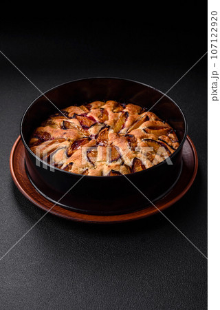 Delicious sweet aromatic homemade pie with ripe plums Delicious sweet aromatic homemade pie with ripe plums 107122920