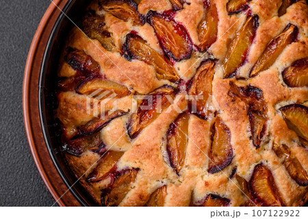 Delicious sweet aromatic homemade pie with ripe plums Delicious sweet aromatic homemade pie with ripe plums 107122922