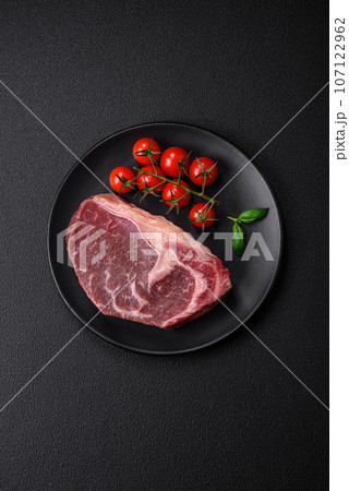 Fresh raw beef striploin steak with salt, spices and herbs 107122962