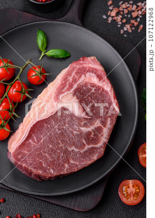 Fresh raw beef striploin steak with salt, spices and herbs 107122968