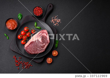 Fresh raw beef striploin steak with salt, spices and herbs Fresh raw beef striploin steak with salt, spices and herbs 107122969