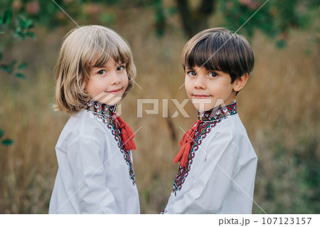 Portrait handsome ukrainian boys apple orchard. Children traditional embroidery 107123157