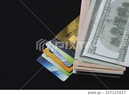 bank plastic credit cards and debit cards and us dollars on a black background 107123837